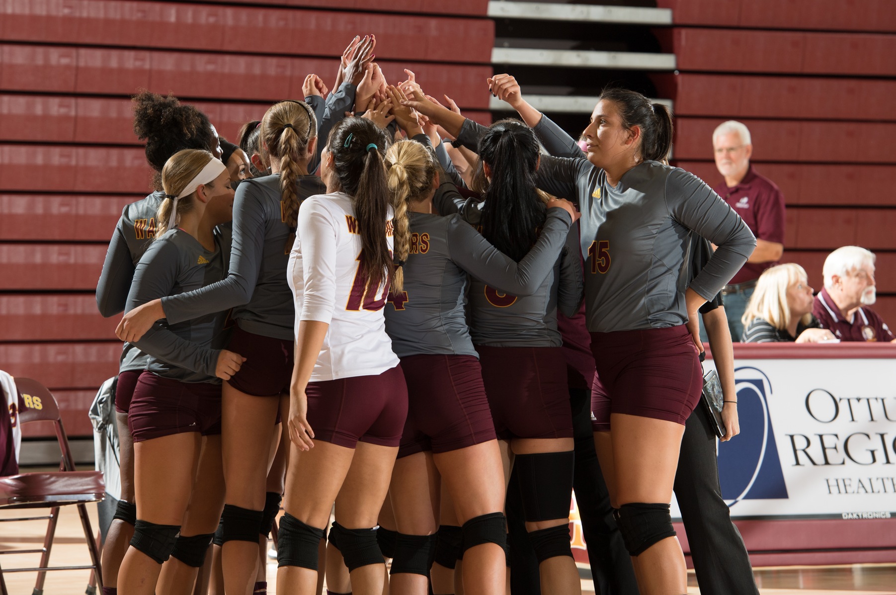 2016-17 Volleyball Team Raising Hands together