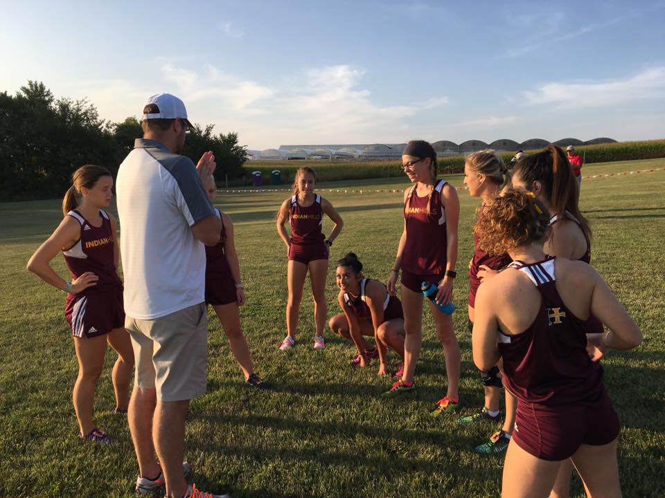 Women's Cross Country runners stretching and talking before the run.